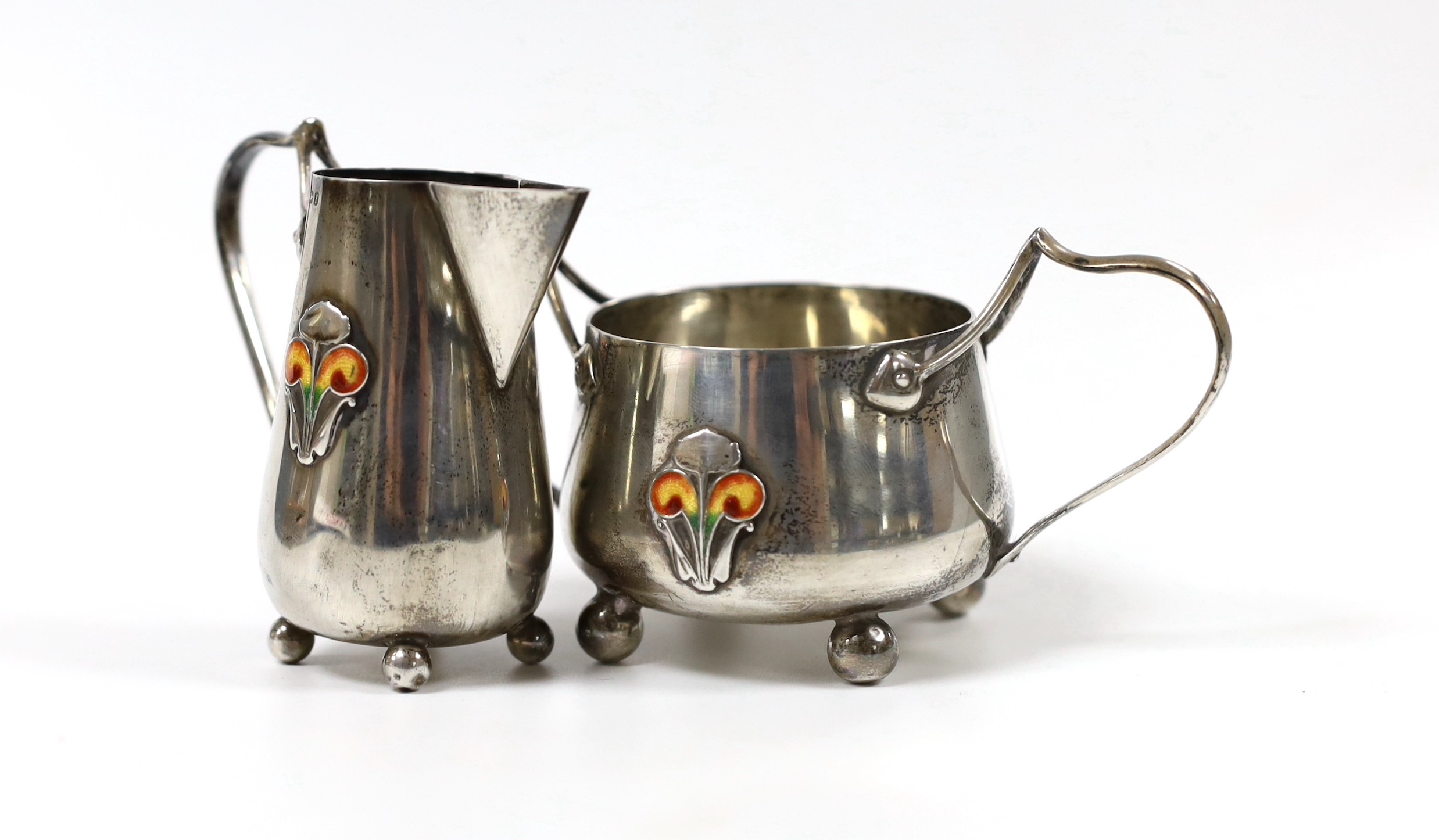 An Edwardian Art Nouveau silver and enamelled cream jug and sugar bowl, C & Co, Birmingham, 1905, jug height 76mm, gross weight 123 grams.